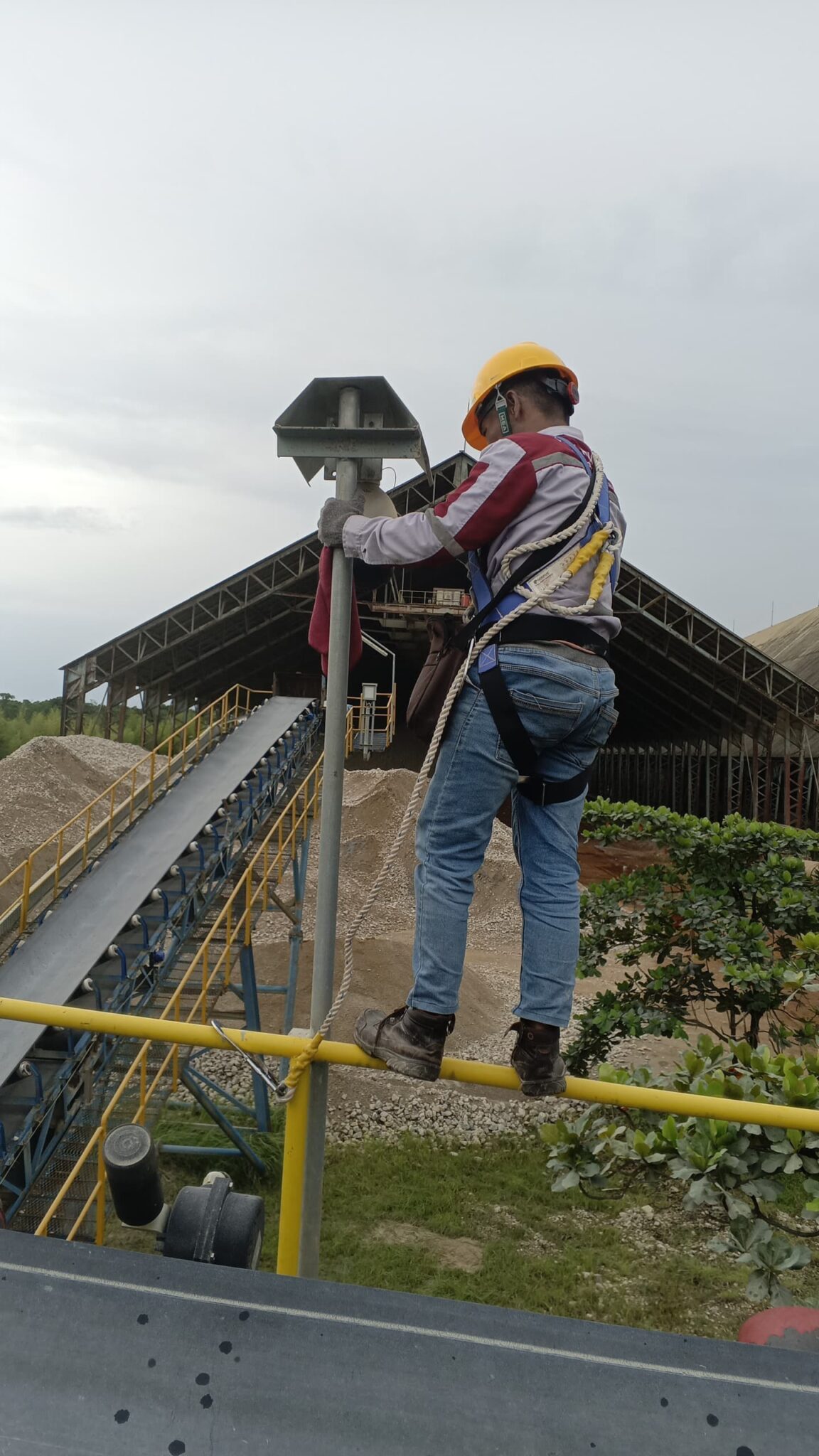 Teknisi CV Dika Prima Solutions melakukan maintenance kamera CCTV industri di area conveyor Batulicin Tanah Bumbu