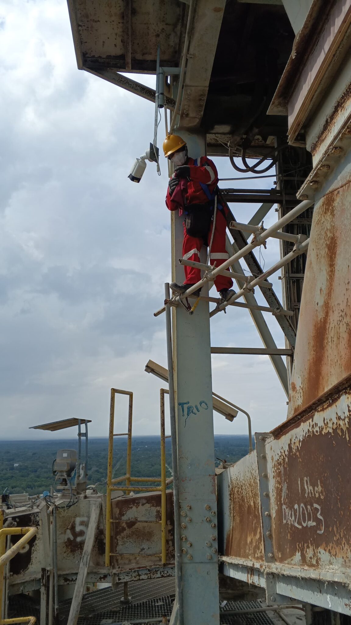 Teknisi CV Dika Prima Solutions melakukan instalasi dan perbaikan kamera CCTV outdoor di area industri Indocement Tanah Bumbu